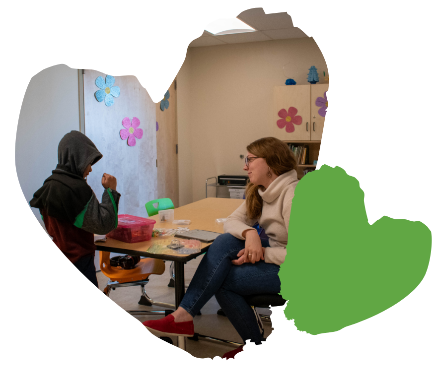 student and speech therapist talking in a classroom