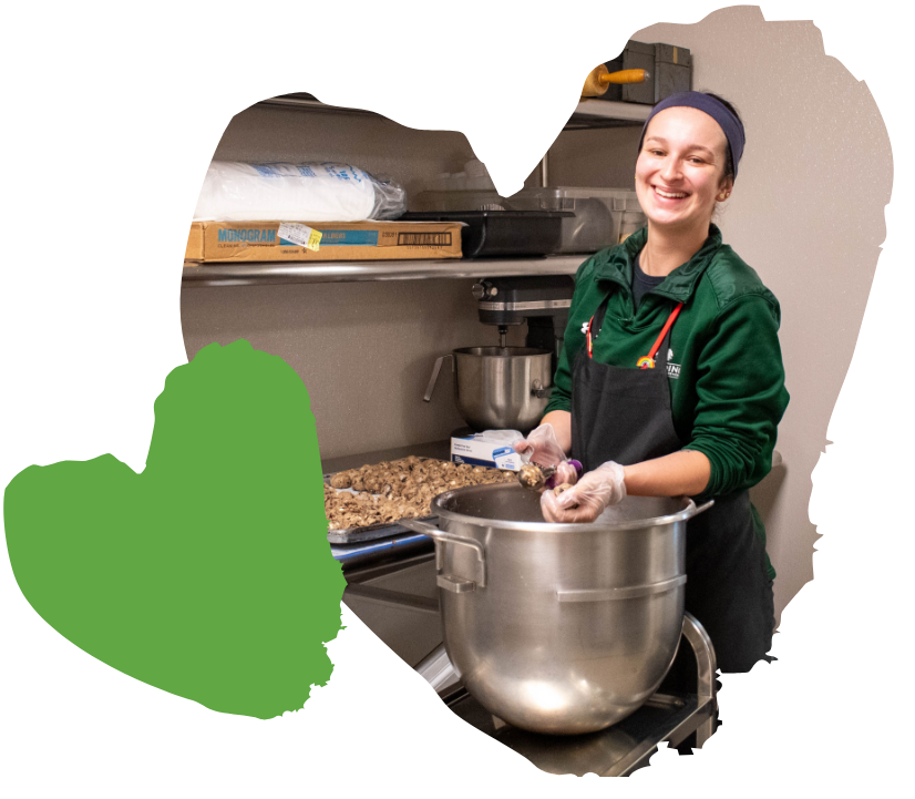 spaulding chef smiles while preparing food in kitchen