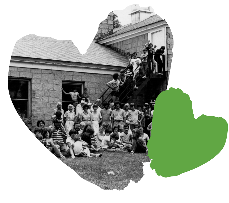 A group of people gathered outside a Spaulding's old building, some sitting on stairs, with a green heart overlay.